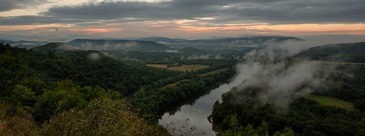 Landscape with mist rising over mountains and river