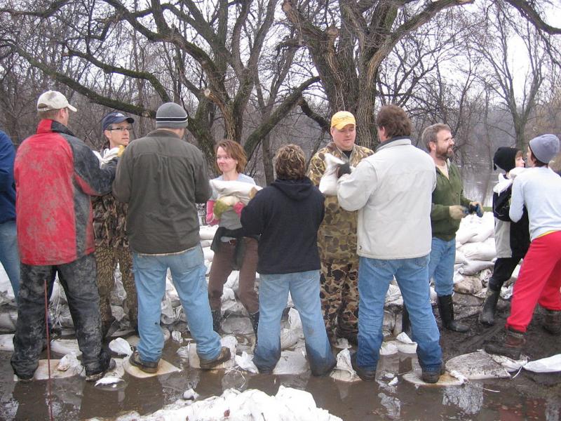 Photo of people passing sandbags