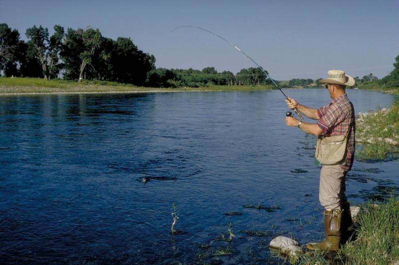 An angler fishing on the bank of a river